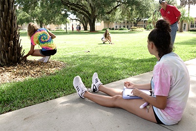 Assistant professor of criminal justice Joseph Cillo works with CSI campers on documentation